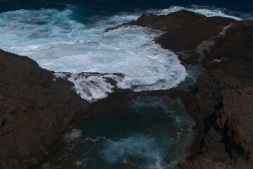 Gran Canaria, north coast, area around Punta Sardina cape, powerful foamy ocean waves breaking along the shore
