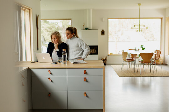 Two women working with laptop at home