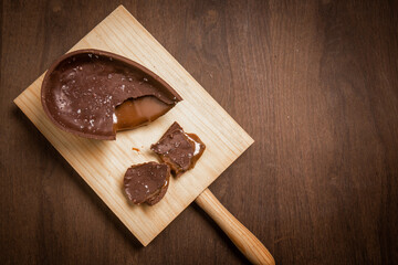 Top view of a cracked chocolate easter egg with flower of salt, stuffed with dulce de leche...