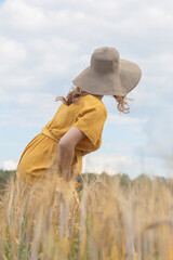 Beautiful young pregnant girl in a wheat field