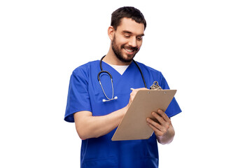 healthcare, profession and medicine concept - happy smiling doctor or male nurse in blue uniform writing medical report on clipboard over white background