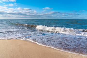 Fototapeta na wymiar Empty beach with yellow sand and blue waves, quarantine at the resort