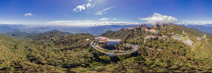 Top aerial view of the famous Golden Bridge is lifted by two giant hands in the tourist resort on Ba Na Hill in Da Nang, Vietnam