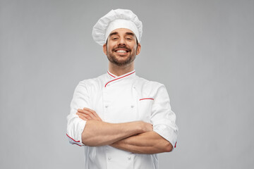 cooking, culinary and people concept - happy smiling male chef in toque and jacket over grey...