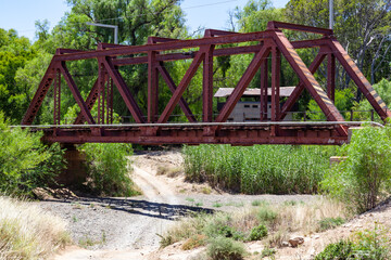 Railway bridge over dry riverbed.
