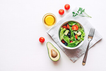Fresh salad of avocado, cherry, arugula and olives made at home. Vegan food. The concept of healthy eating. Top view.
