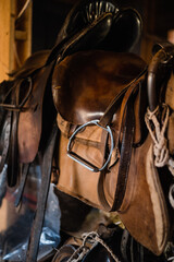 A set of riding equipment in a wooden stable at the equestrian club.