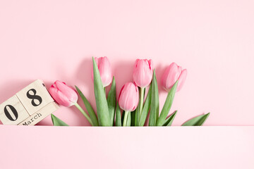 Beautiful pink tulips and calendar on pastel pink background. Concept Women's Day, March 8. 8th march. Flat lay, top view, copy space