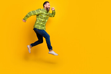 Fototapeta na wymiar Full size profile side photo of excited man happy positive smile jump go walk run hurry sale isolated over yellow color background