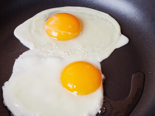 Scrambled eggs in an iron pan on the rustic wooden table