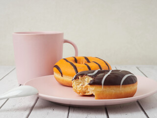 Delicious glazed donuts on white wooden table. Space for text