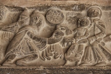 A nearly naive Romanesque relief in dark grey stone depicting the Adoration of the Magi at Huesca Cathedral, Spain