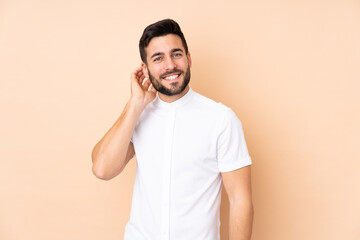 Caucasian handsome man isolated on beige background laughing