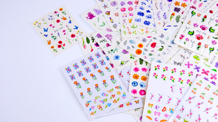 multicolored stickers for manicure on a white background, background