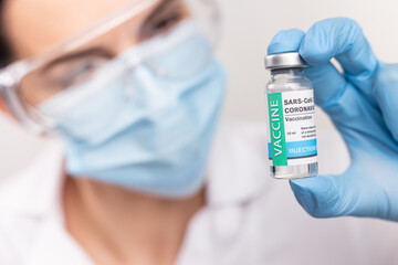 SARS - CoV2 Vaccination concept. Close up COVID-19 vaccine dose. A doctor or nurse in a laboratory...