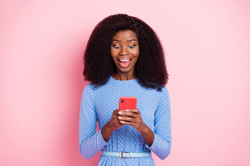 Photo of excited lady hold phone look screen open mouth crazy face wear blue dotted dress isolated...