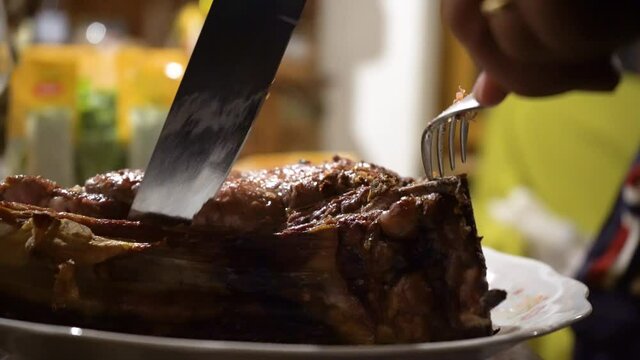 A person is cutting a Florentine steak on a table with a knife