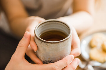 Female hands holding hot cup of coffee or tea