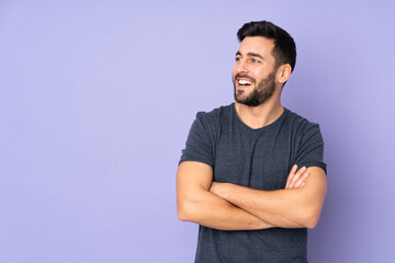 Caucasian handsome man happy and smiling over isolated purple background