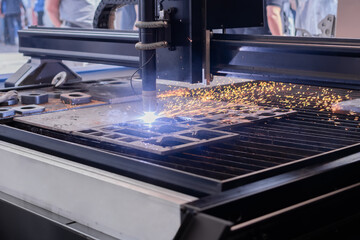 Automatic cnc plasma cutting machine working with sheet metal with sparks at factory, plant....