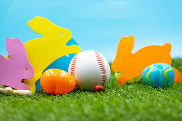 Baseball with Easter eggs are on green grass for Easter Holiday