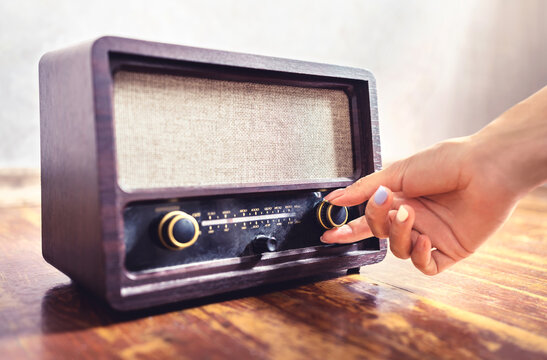 Retro radio tuning. Woman using old vintage music equipment. Adjusting volume or frequency tuner knob. Turning on or off stereo receiver or speaker. Changing channel or station with dial button.