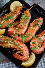 Grilled large queen shrimps with lemon and spices on the grill pan