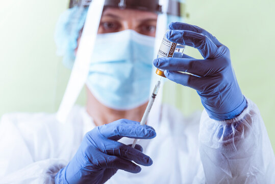 Vaccination, doctor in protective clothes with syringe and ampule