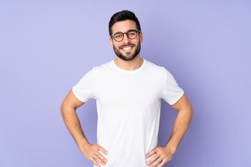 Caucasian handsome man over isolated background posing with arms at hip and smiling