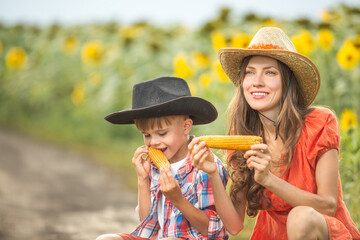Beautiful mother and son eating corn outdoors