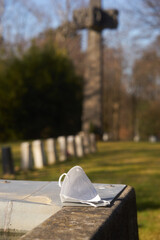 mask lying on a graveyard symbolising covid19 and death