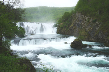 Fototapeta na wymiar The beautiful landscape of Bosnian nature with a cascade waterfall in the National park Una in Bosnia and Herzegovina in spring