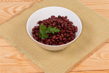 Boiled red kidney beans in white bowl on a placemat