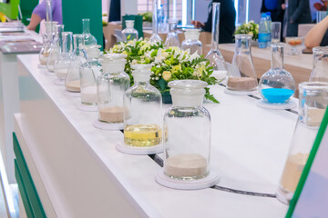 Exhibition stand design - glass bottles with different chemical reagents samples on conveyor belt at trade show. Science, laboratory concept