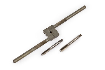 Different taps and tap wrench on a white background