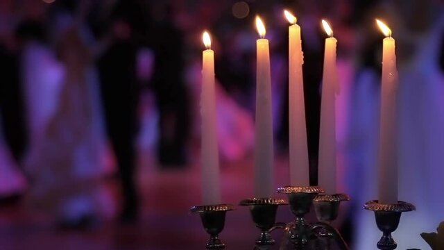 Dancing couples, burning candle and beautiful flowers. Traditional Vienna ball.