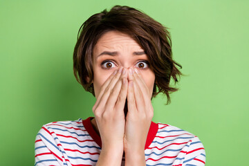 Close-up portrait of pretty worried girl got spooky news closing face omg isolated over green pastel color background