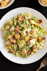 Homemade Bacon Avocado Caesar Salad with Cheese and Croutons, top view. Close-up.