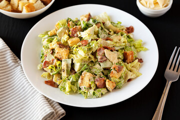 Homemade Bacon Avocado Caesar Salad with Cheese and Croutons, low angle view. Close-up.