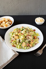 Homemade Bacon Avocado Caesar Salad with Cheese and Croutons, low angle view.