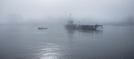 ferry in the mist on river lek near culemborg and utrecht