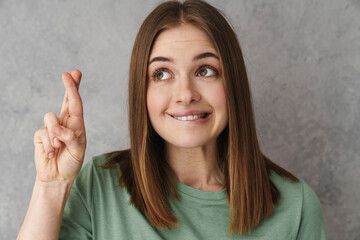 Pleased beautiful nice girl holding fingers crossed for good luck