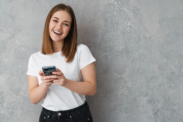 Happy nice charming girl smiling and using cellphone