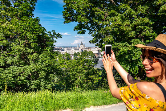 A young woman taking pictures of Budapest