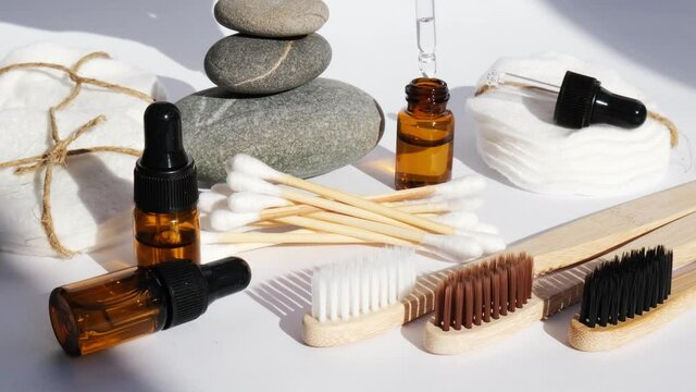 Reusable and recycable bathroom accessories on white background. Trendy shadows. Zero waste concept. Natural cosmetics and eco living concept. Essential oil or serum