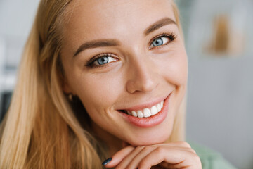 Happy blonde young woman smiling and looking at camera