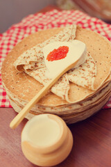 Russian pancake blini with fresh cream on wooden background