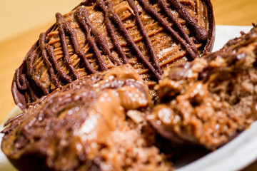 Dulce de leche easter egg on a white plate on a wooden table.