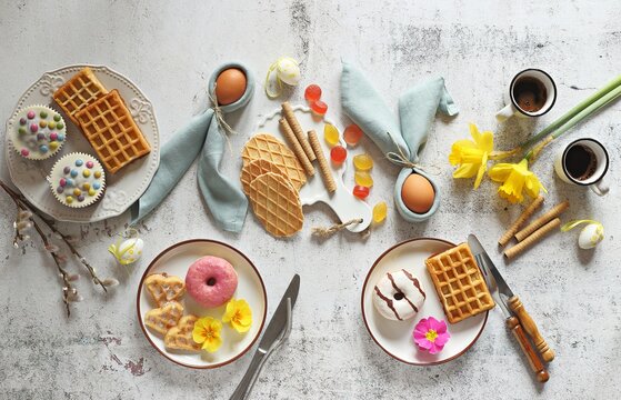 Flat layot from  festive dessert table with various of waffles, cake, muffins and sweets.