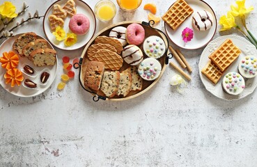 Flat layot from  festive dessert table with various of waffles, cake, muffins and sweets.